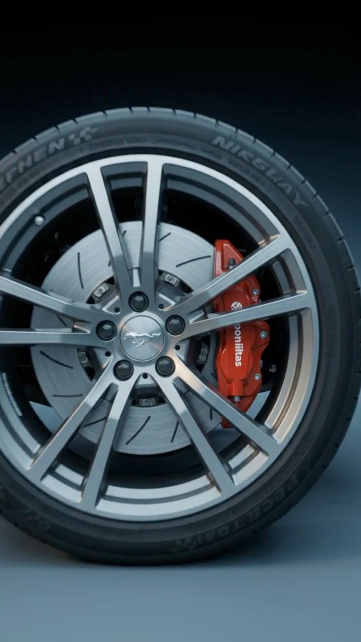 A 10-second automotive detail video: a spinning alloy wheel and red brake caliper, a powertrain lit from inside, then an illuminated grille badge.
